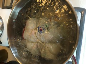 Trussed up pudding in boiling water.